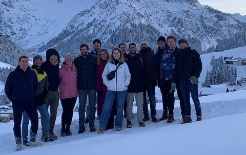 Es ist eine Gruppe junger Menschen zu sehen, die in einer Winterlandschaft stehen