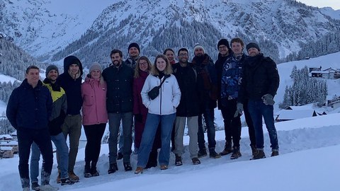 Es ist eine Gruppe junger Menschen zu sehen, die in einer Winterlandschaft stehen