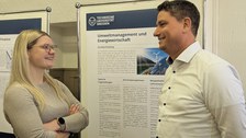 Zu sehen sind Prof. Möst und Lisa Junge, die sich vor einem Poster unterhalten.