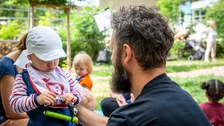  Ein Vater spielt mit seinem Kind auf einem Spielplatz des Kindergartens "Campus-Kiste". Das Kind hält Spielzeug in der Hand.