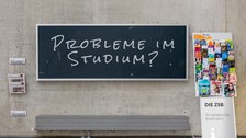Foto: Eine Tafel hängt im Chemiebau an der Wand. Darauf steht "Probleme mit dem Studium?