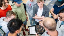 Foto einer Gruppe Studierender und ihrem Dozenten aus der Vogelperspektive. Der Dozent erklärt seinen Studenten was Schweißköpfe sind und hält dabei einen in der Hand.
