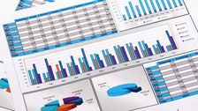 Das Foto zeigt mehrere Papiere mit verschiedenen Diagrammen und Statistiken.