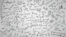 Auf dem Foto sind viele mathematische Symbole und Formeln zu sehen, die auf einen weißen Hintergrund geschrieben wurden