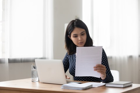 Eine Frau liest Studiendokumente