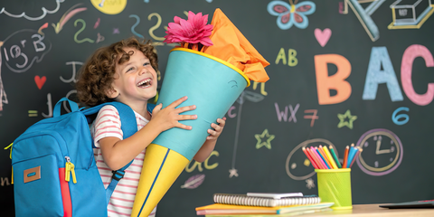Es ist ein Mädchen mit Zuckertüte zu sehen.