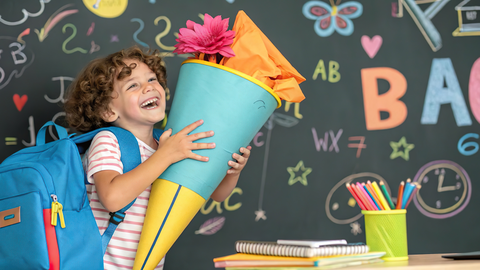 Es ist ein Mädchen mit Zuckertüte zu sehen.