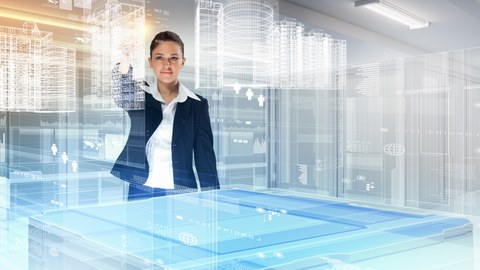 Das Foto zeigt eine Frau vor einem hochmodernen Tisch. Auf dem Tisch erkennt man virtuelle dreidimensionale Modelle von Gebäuden.