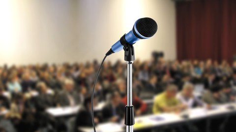 Mikrofon vor einem Saal mit Konferenzteilnehmer*innen