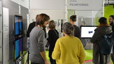 Mehrere Besuchende auf der Ausstellung im Gespräch und in Betrachtung der Exponate.