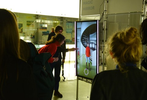 Besuchende testen auf der Ausstellung DataSpaces am Display das Exponat Magic Mirror.
