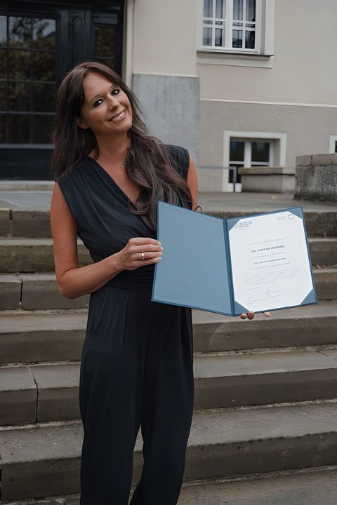 Foto. Dr. Sandra Hummel präsentiert stolz die TUD Young Investigator Urkunde.