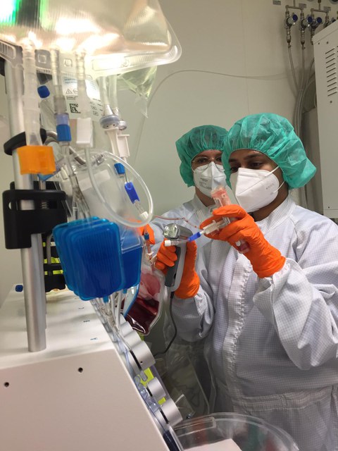 3 people in lab dressed in overall with face mask