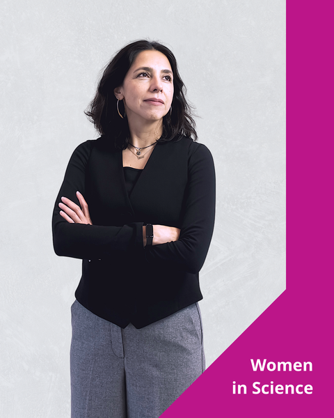Ein Foto mit grafischen Elementen. Eine Person steht mit verschränkten Armen da und schaut leicht nach oben und weg von der Kamera. Auf der rechten Seite befindet sich ein rosa visuelles Element mit dem Text „Women in Science” (Frauen in der Wissenschaft) unten.