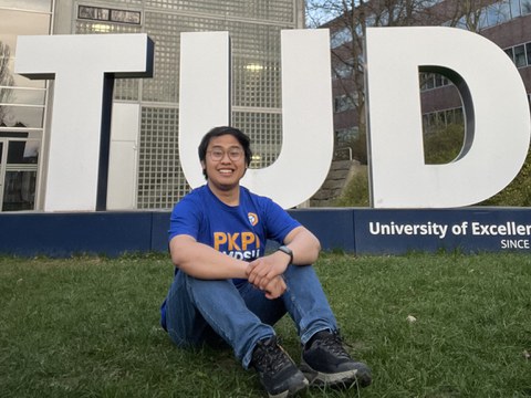 Oka Ramadhan vor den 3D-Buchstaben „TUD“ auf der Wiese hinter dem HSZ