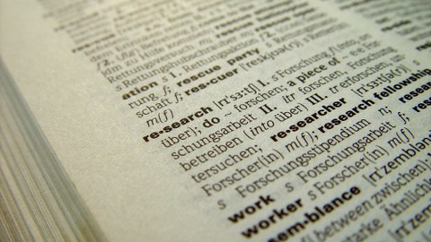 Das Foto zeigt die Seite eines aufgeschlagenen Wörterbuchs. Im Zentrum des Bildes steht das Wort "research".