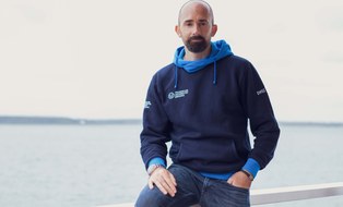 Foto Mann Marko Schimke im blauen Pullover mit DHSZ-Logo