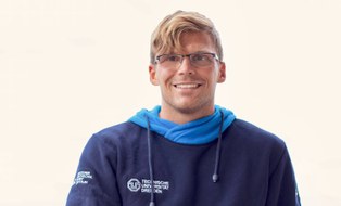 Foto Mann Stephan Möller im blauen Pullover mit DHSZ-Logo