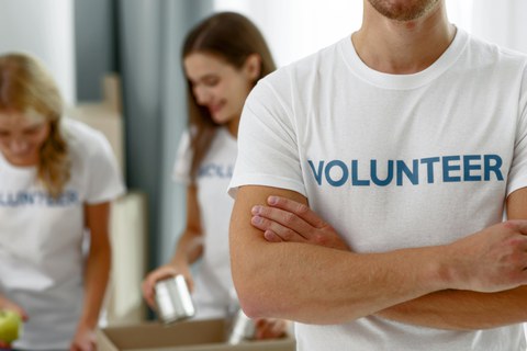 Foto muskulöser Mann im weißen Shirt mit der Aufschrift "Volunteer"