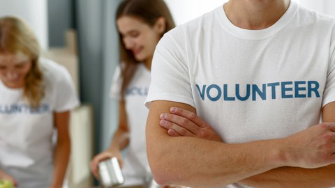 Foto muskulöser Mann im weißen Shirt mit der Aufschrift "Volunteer"