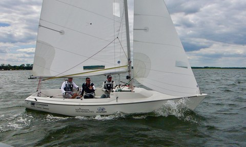 Foto: Segelboot mit drei Männern auf dem Wasser