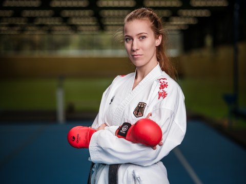 Foto: junge Frau im Karate-Anzug und roten Handschuhen
