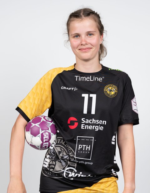 junge Frau in Sportkleidung mit Handball unterm Arm