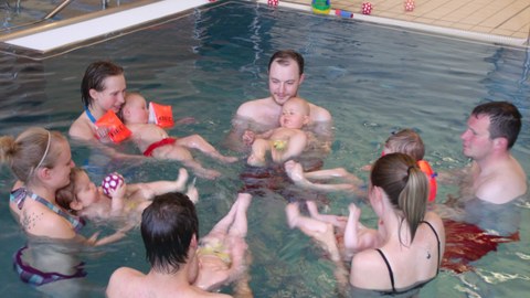 Eltern mit Kleinstkindern im Schwimmbecken
