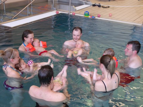 Eltern mit Kleinstkindern im Schwimmbecken