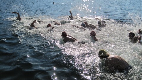 Foto viele Personen laufen ins Wasser 
