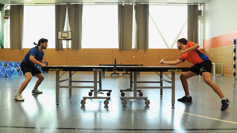 Foto: 2 Sportler stehen sich an einer Tischtennisplatte gegenüber