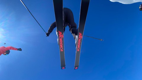 Skifahrer überspringt Fotografen