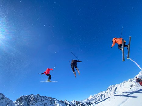 Drei Skifahrer im Sprung