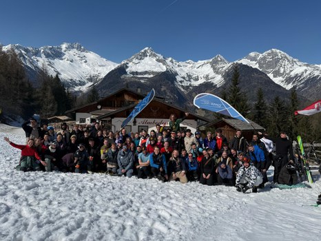Gruppenfoto: große Gruppe vor alpiner Berglandschaft im Schnee