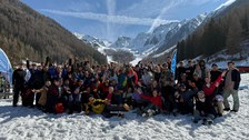 Gruppenfoto: große Gruppe vor alpiner Berglandschaft im Schnee