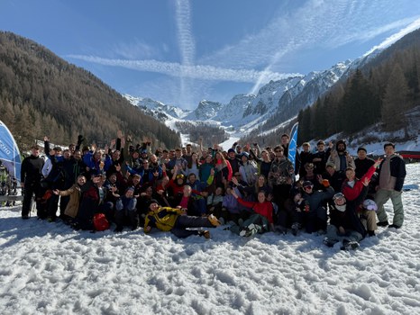 Gruppenfoto: große Gruppe vor alpiner Berglandschaft im Schnee