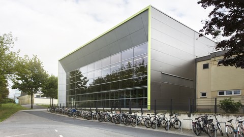 Foto Sporthalle mit Glasfassade, davor viele Fahrräder