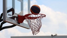 Ein Basketball fällt gleich in den Korb