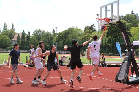 Mehrere Basketball-Spieler beim Korbwurf, ihre Haltung in der Luft wirkt, als würden sie eine Treppe hinaufgehen