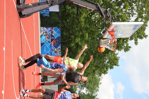 Mehrere Basketball-Spieler synchron beim Korbwurf