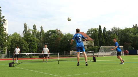 Mehrere Spieler beim Fußballtennis, der Fußball wird über ein Tennisnetz gespielt