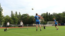Mehrere Spieler beim Fußballtennis, der Fußball wird über ein Tennisnetz gespielt
