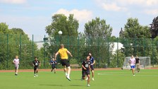 Mehrere Spieler beim Fußball, einer ist in der Luft beim Kopfball