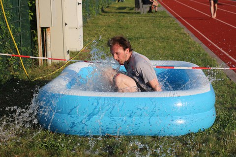 Beim Parkour-Wettbewerb: ein Mann spingt ins Mini-Wasserbecken
