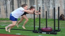 Beim Parkour-Wettbewerb: zwei Frauen schieben eine Vorrichtung mit Gewichten
