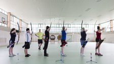 Foto: 6 Sportler zielen mit Pfeil und Bogen auf Zielscheiben