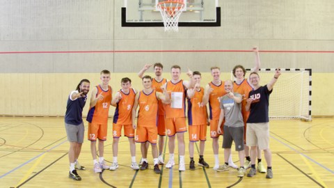 Foto: Mannschaft in orangenen Trikots feiern ihren Sieg bei der DHM Basketball