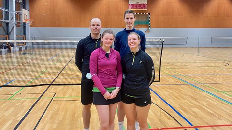 Foto 2 Frauen und 2 Männer stehen in einer Sporthalle vor einem Volleyballnetz