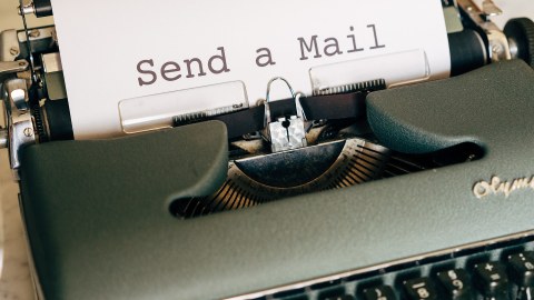 Eine Schreibmaschine, in die ein weißes Blatt Papier eingespannt ist. Auf dem Blatt steht "Send a Mail" 
