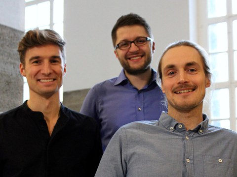 Photo: the founders of Clover Optimization, Maurice Morabel, Leopold Kuttner and Felix Tamke, stand together in a group and smile at the camera.